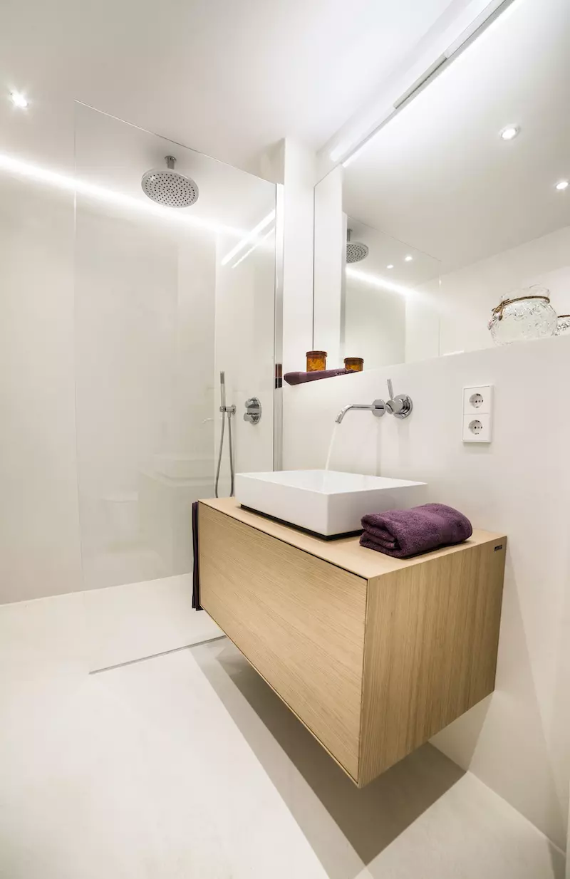 Modernes, fugenloses Badezimmer mit Holz-Waschtisch und Regendusche in Köln